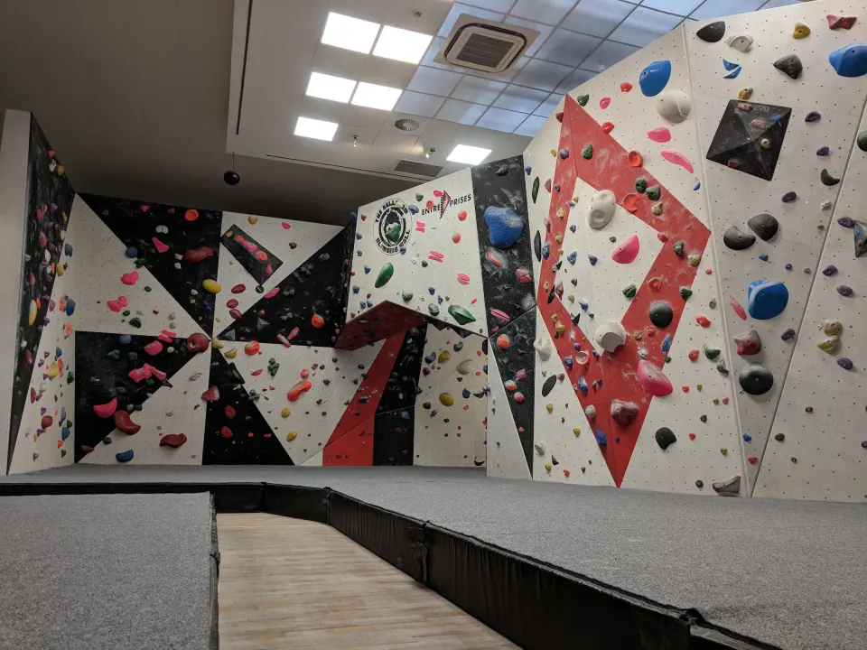 Red, black and white bouldering walls above grey matting