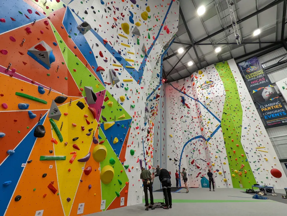 Tall roped walls with colourful panels and an auto belay lane