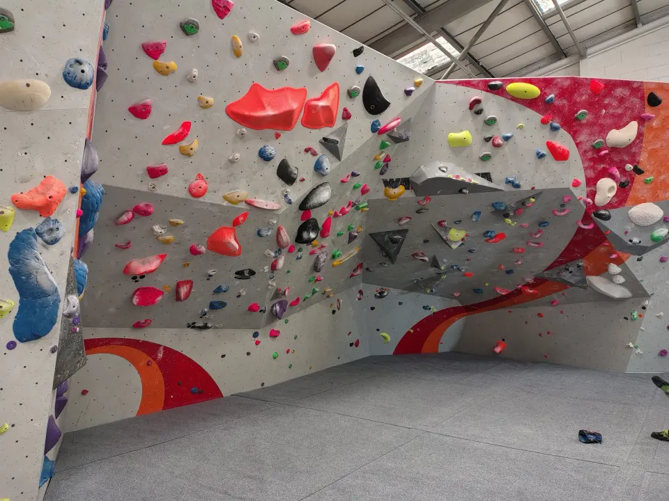 Grey and red bouldering walls with a swooping orange stripe