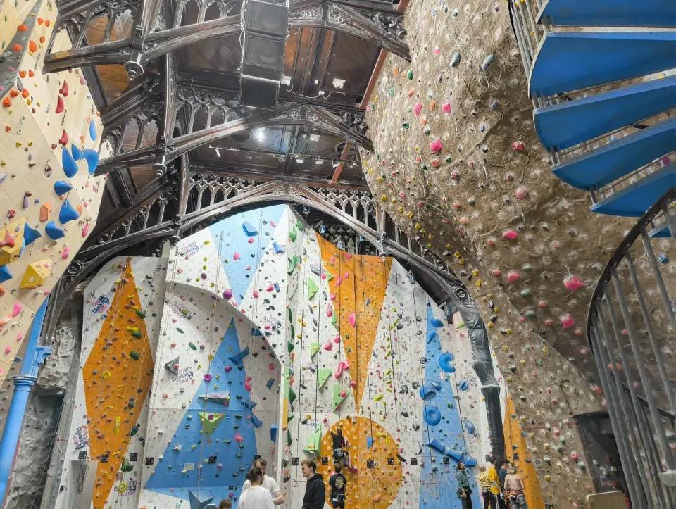 Roped climbing walls under the iron arches and roof of the old church