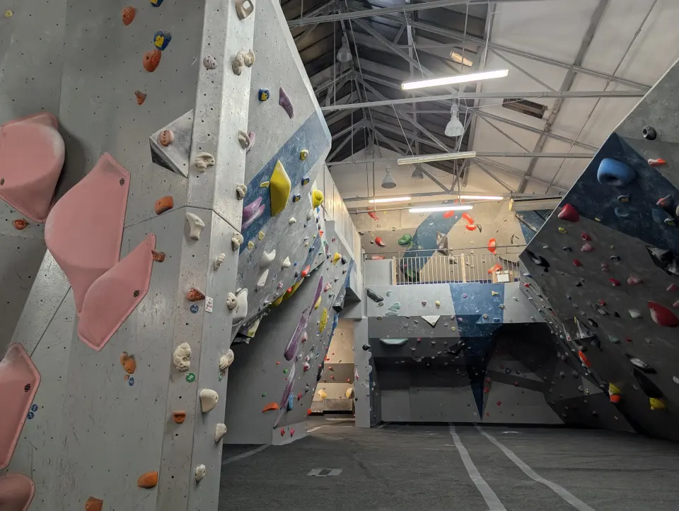 Grey bouldering walls and arêtes under the roof trusses