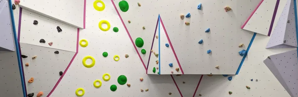 Freshly set bouldering wall with coloured holds and volumes
