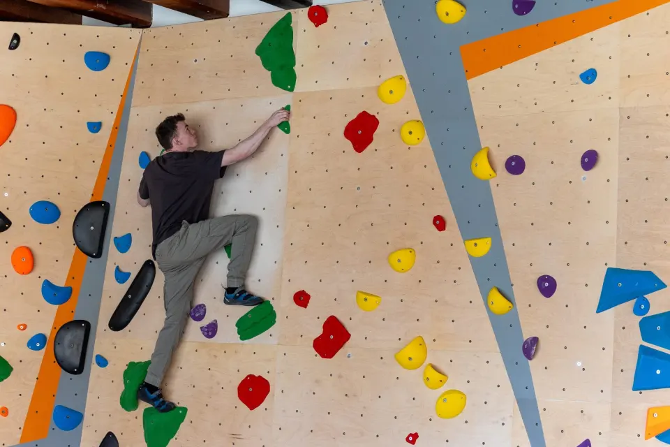 Boulderer on the wooden-panelled wall in the Bouldering Zone