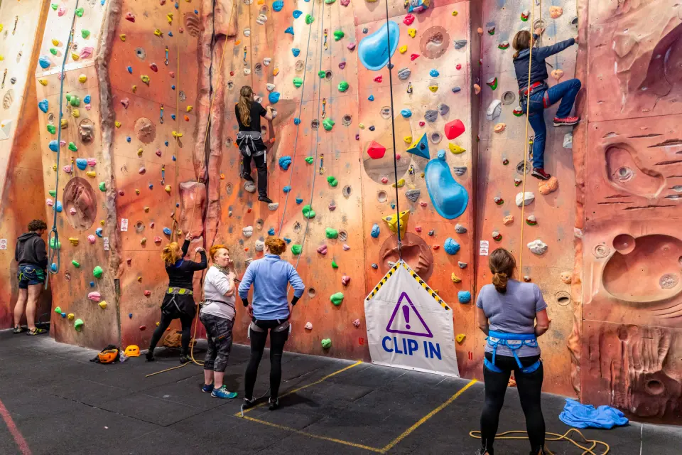 Climbers and belayers at the tall roped wall