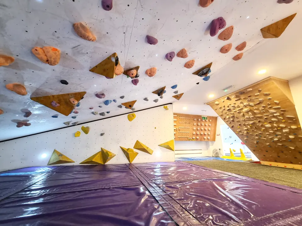 Overhanging bouldering wall with volumes over thick matting