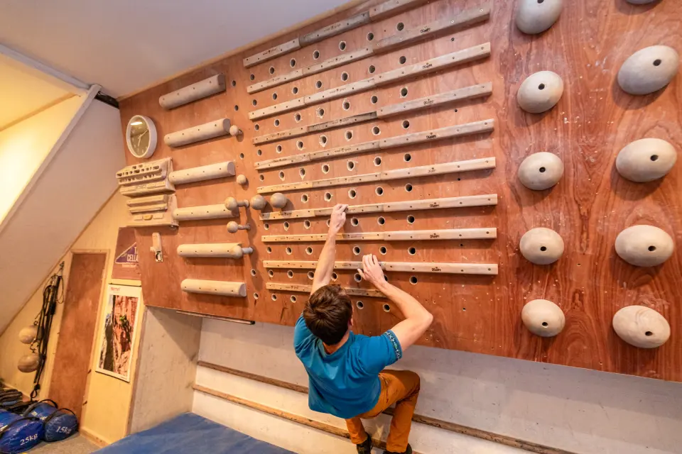 Climber on the peg board and campus board