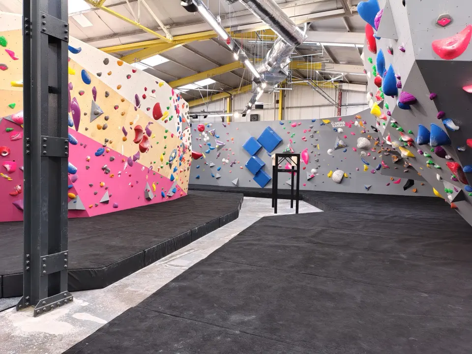 Pink, white and grey bouldering walls along the matted hall