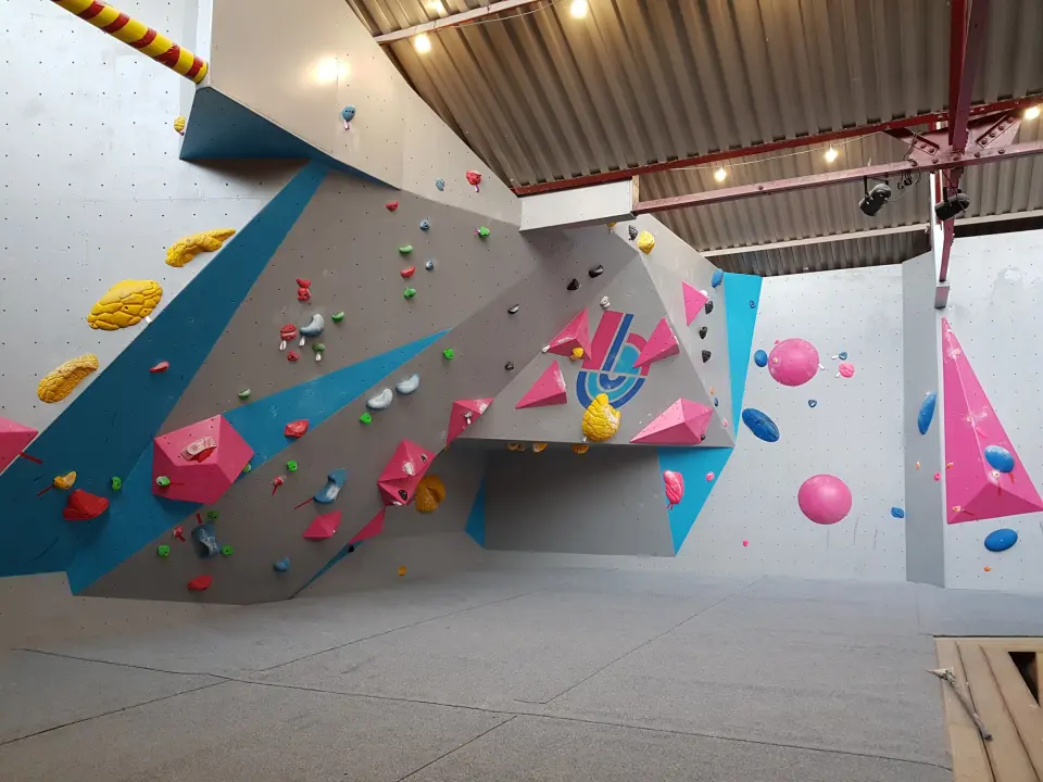 Grey, blue and pink bouldering walls with the Shack logo