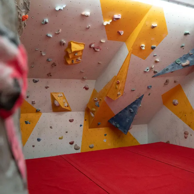 Corner of the bouldering wall above red matting