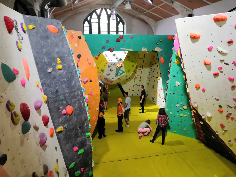 Bouldering room with angled walls under the church's arched window