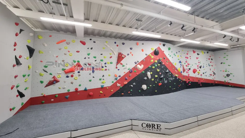 Long bouldering wall with a red and black overhang