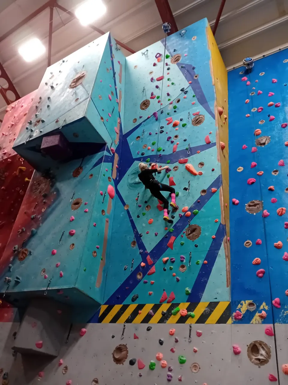 Climbers on the blue and turquoise featured wall