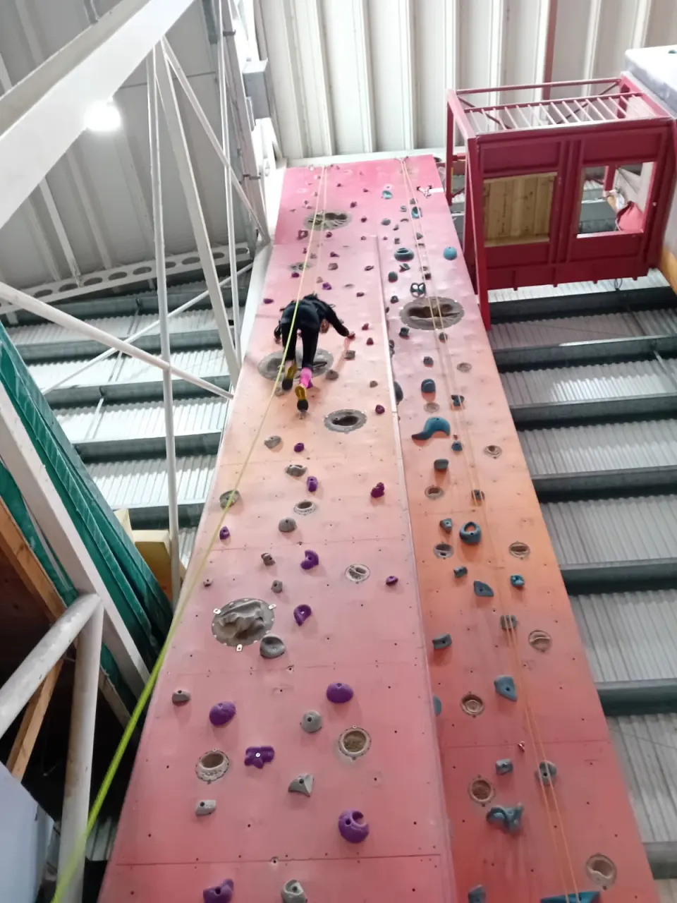 Climber on the red and orange tower, seen from below
