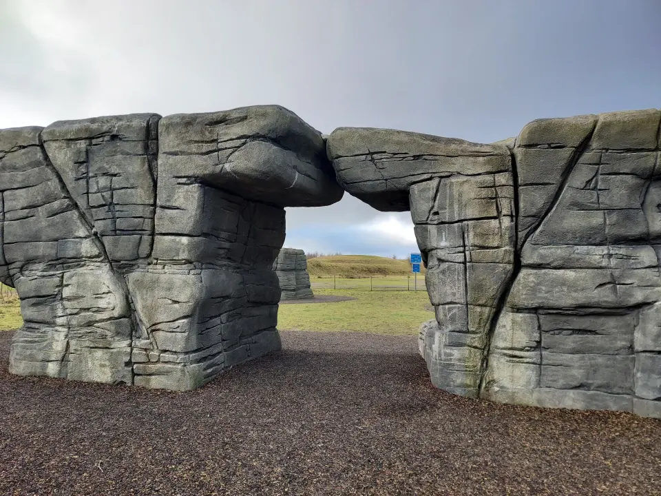 Two grey artificial boulders joined by a stone bridge