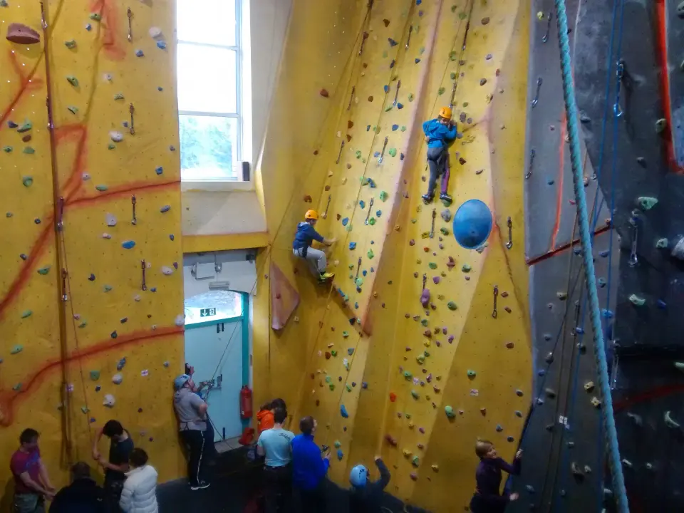 Climbers on the tall yellow roped walls in the main hall