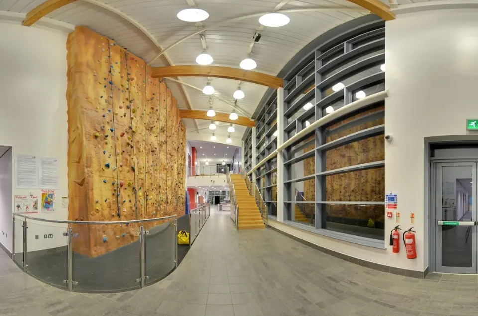 Rock-effect climbing wall rising beside the centre's concourse