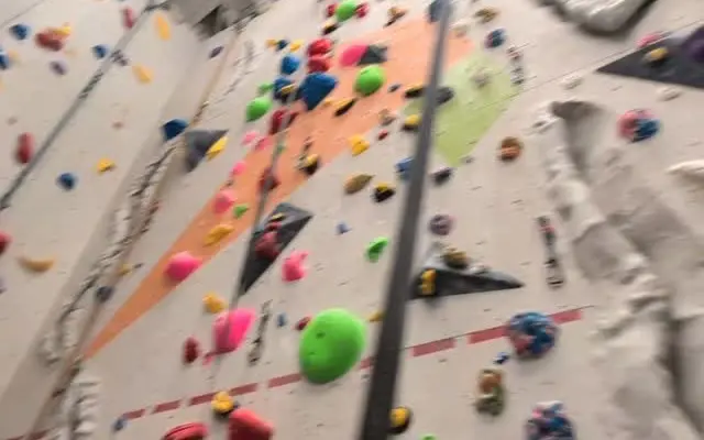 Auto-belay lines and coloured holds on the roped wall