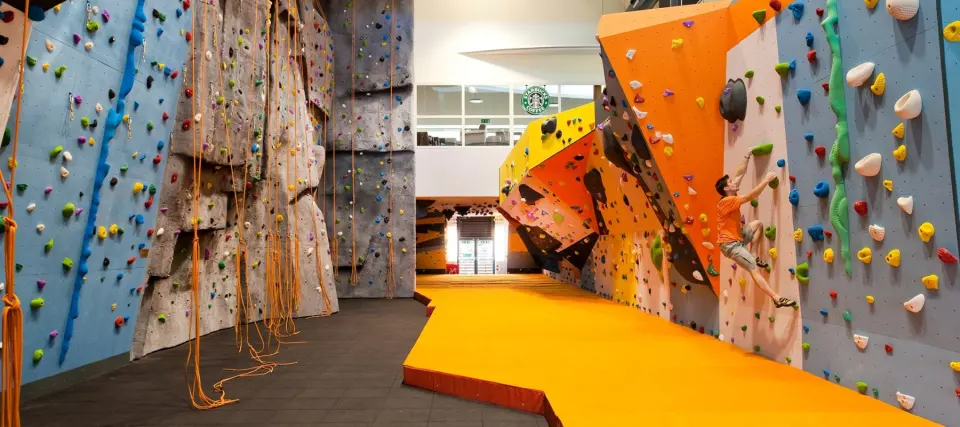 Grey rope walls on the left and the orange bouldering area on the right