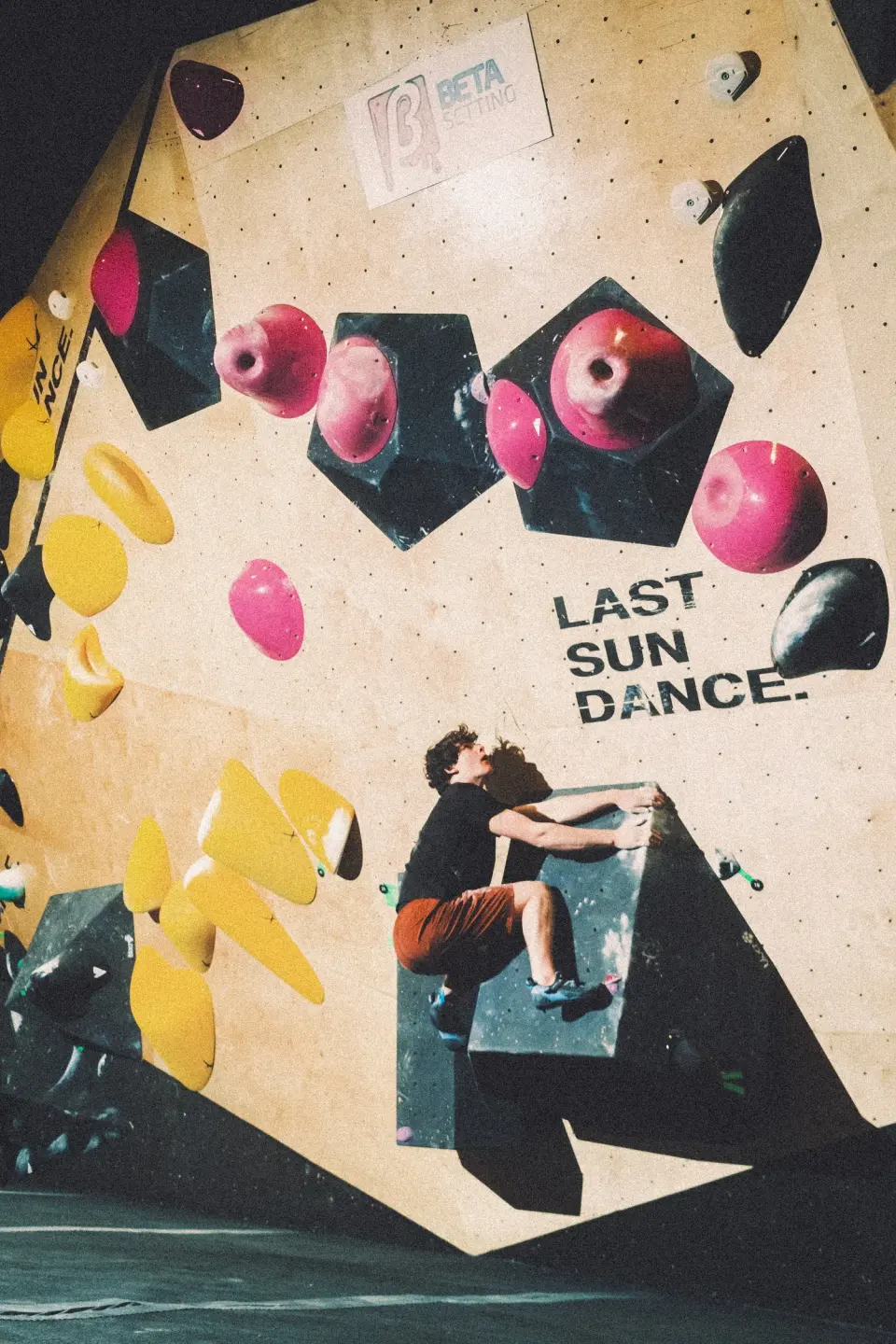 Climber on a steep wall painted with the Last Sun Dance name