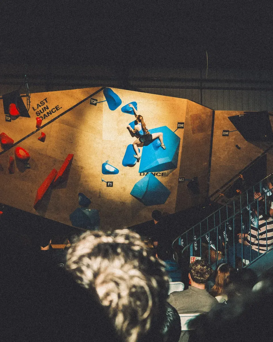 View from above of a climber on a lit bouldering wall