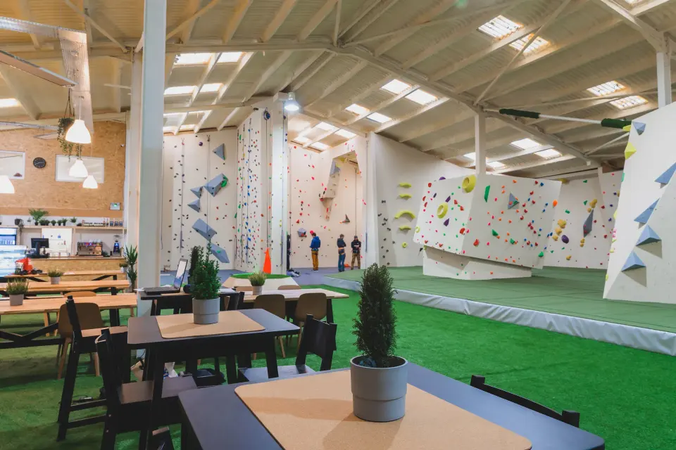 Wide view of the Padstow centre with café tables and bouldering walls behind