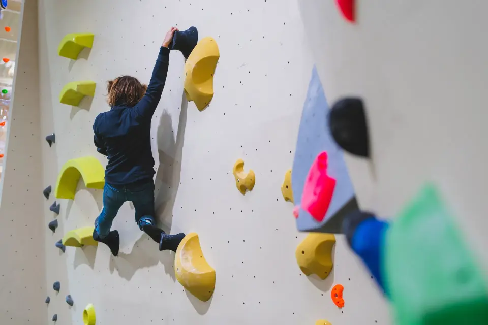 Climber bouldering on yellow holds