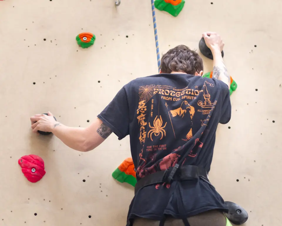 Climber in a harness on a roped route