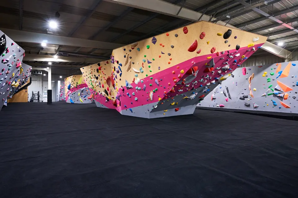 Pink and wood-panelled bouldering blocks across the main hall
