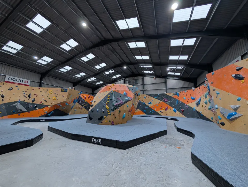 The bouldering hall with its central top-out boulder and orange and grey walls