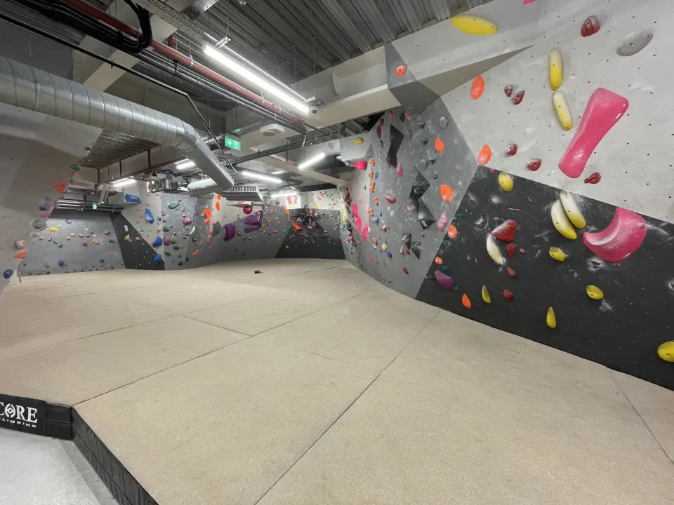 Long grey and black bouldering wall stretching along the basement