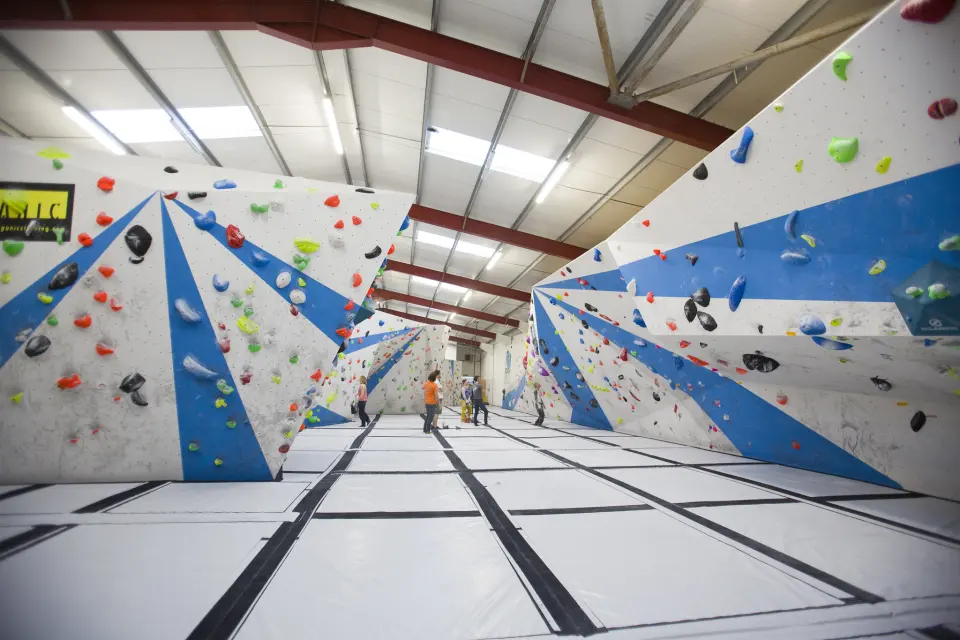 Long view down the bouldering hall with blue and white walls
