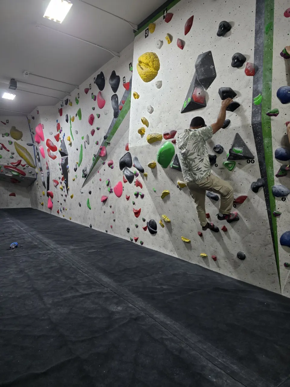 Climber on a long vertical bouldering wall
