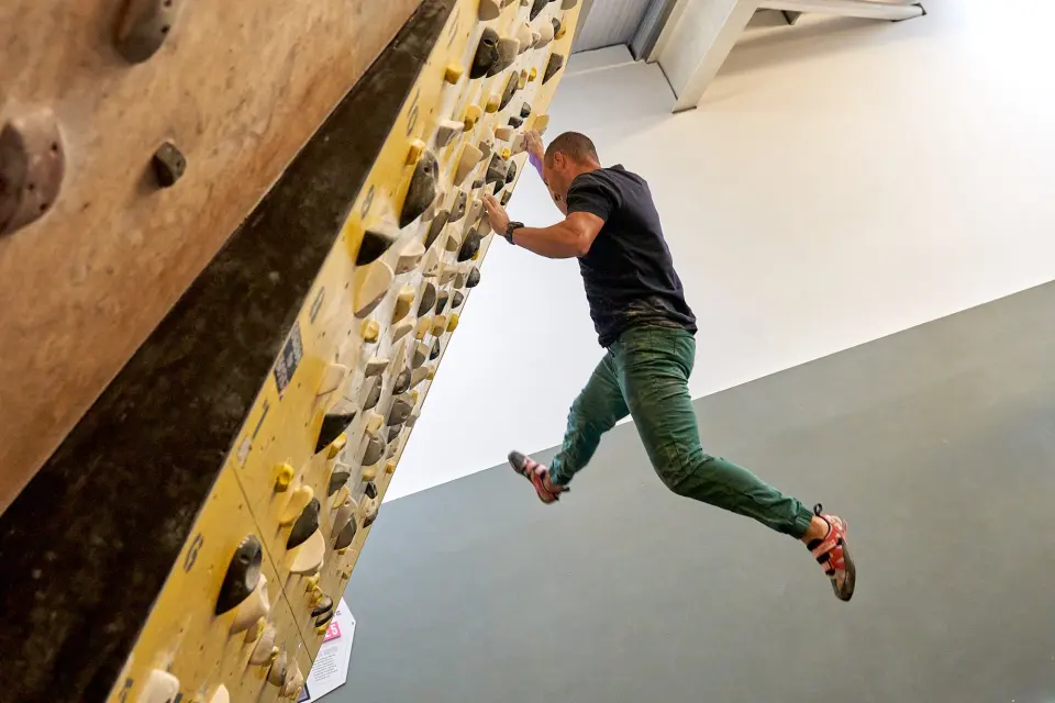 Climber swinging on the wooden training board