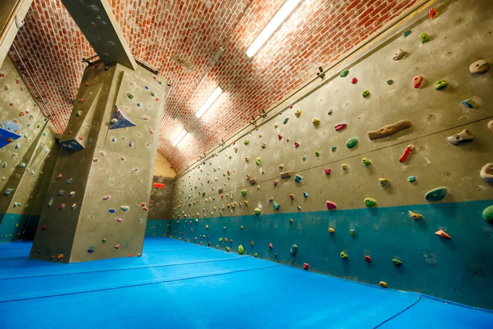 Training Room under the brick vault, with a tall tower and long wall above blue matting