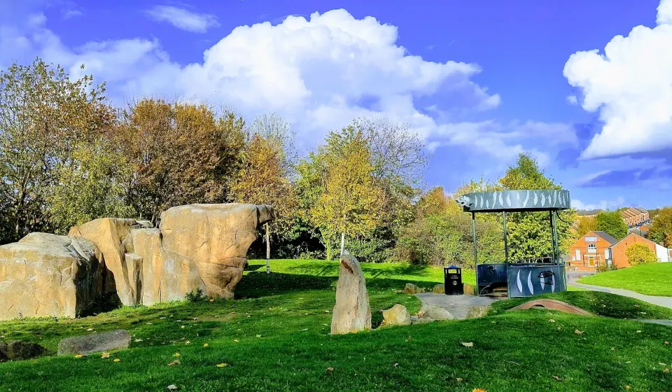 Sculpted sandstone-coloured climbing boulder on the grass in Darnall Community Park