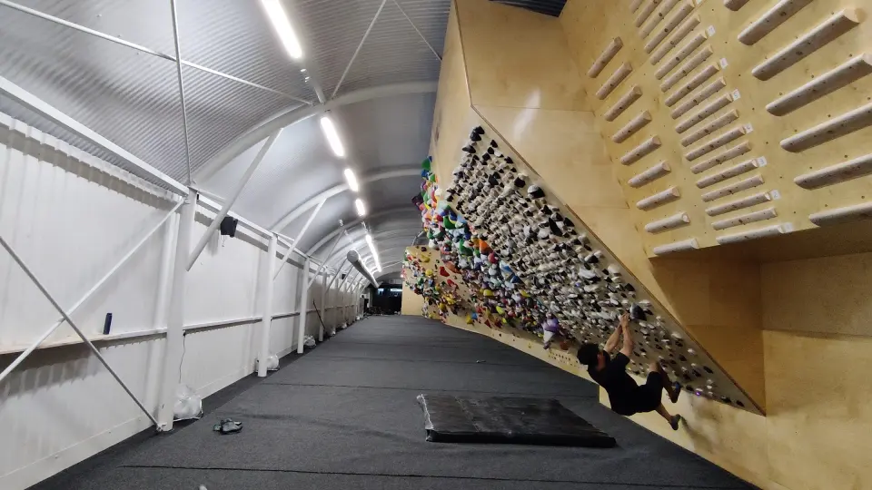 Steep plywood spray wall running the length of the railway arch