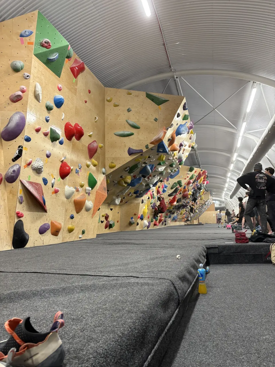 Angled bouldering walls along the arch with thick matting