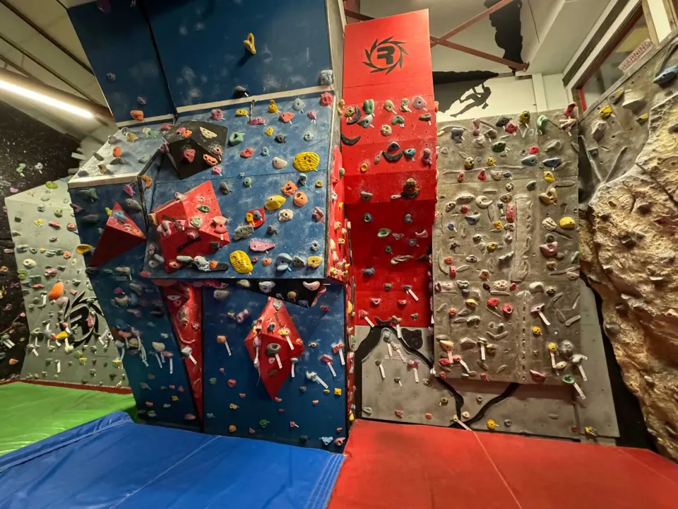 Blue, red and grey bouldering walls with volumes above coloured matting