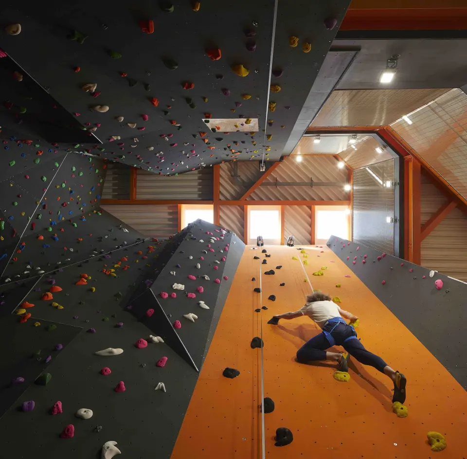 Climber on the orange speed lane beneath a steep roof