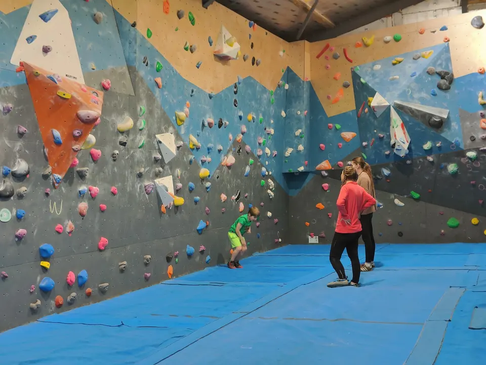 Bouldering wall with blue matting and a corner of steep panels