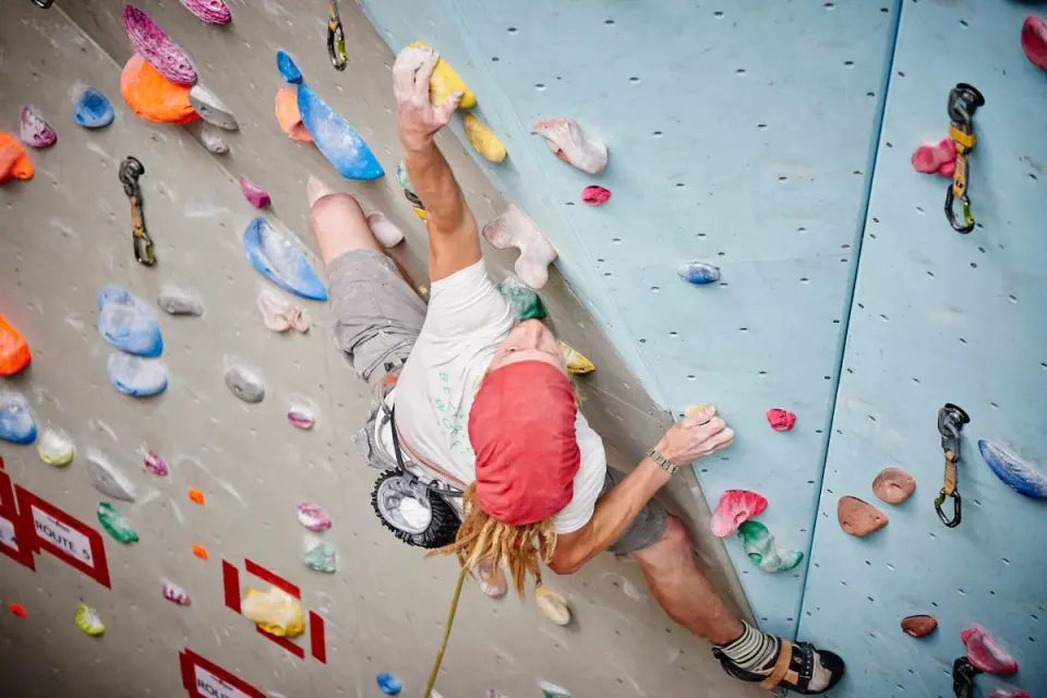 Lead climber on a grey wall seen from above