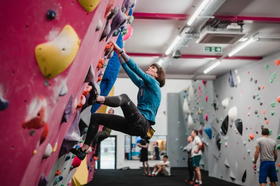 Climber on a pink wall with a view down the hall