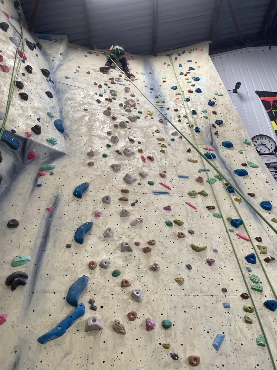 Top-rope wall with colourful holds seen from below