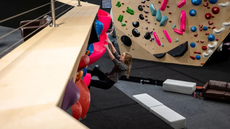 Climber on the vertical wall beside a painted mural