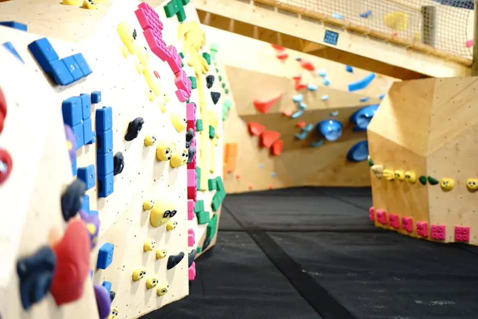 Kids' area bouldering walls under a mezzanine