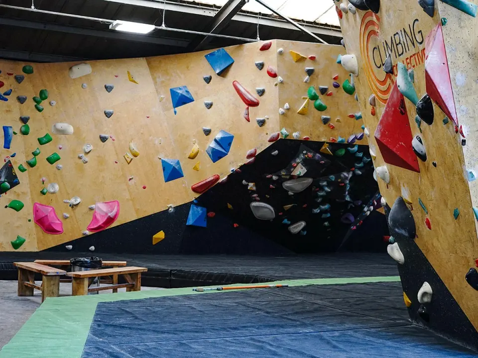 Main bouldering wall with a black overhang and colourful volumes
