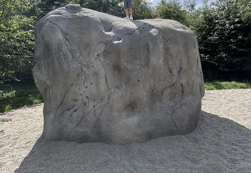 Sculpted concrete boulder on a pebble landing