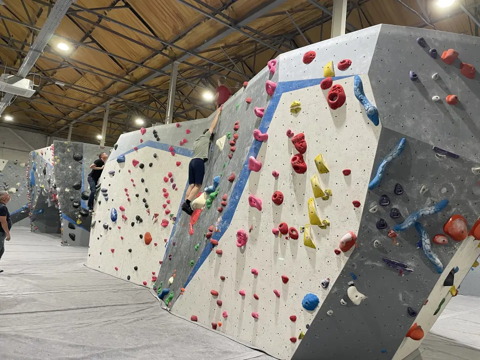 Freestanding bouldering blocks under the wooden roof of the main hall