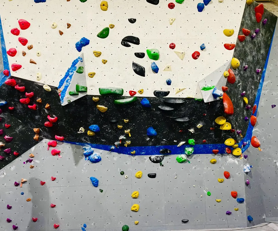 Overhanging bouldering wall covered in colourful holds