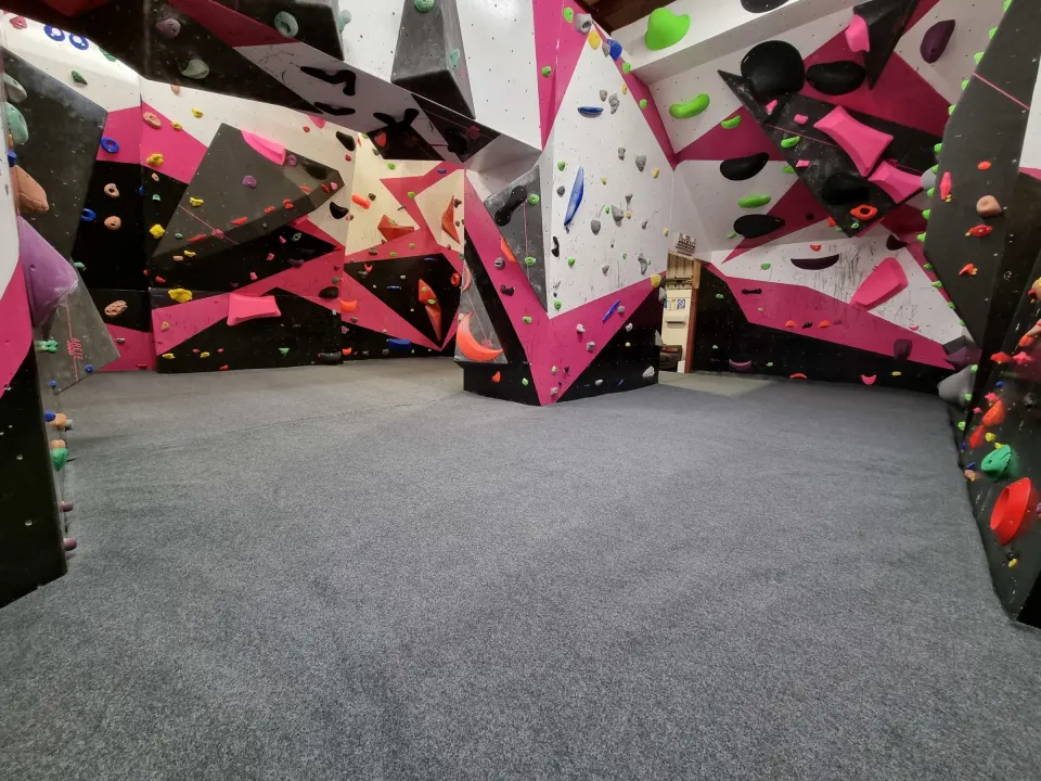 Pink, black and white bouldering walls around a central block
